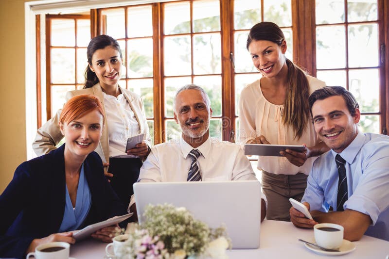 Business people looking at camera in restaurant stock photo Business people looking at camera in restaurant stock photo