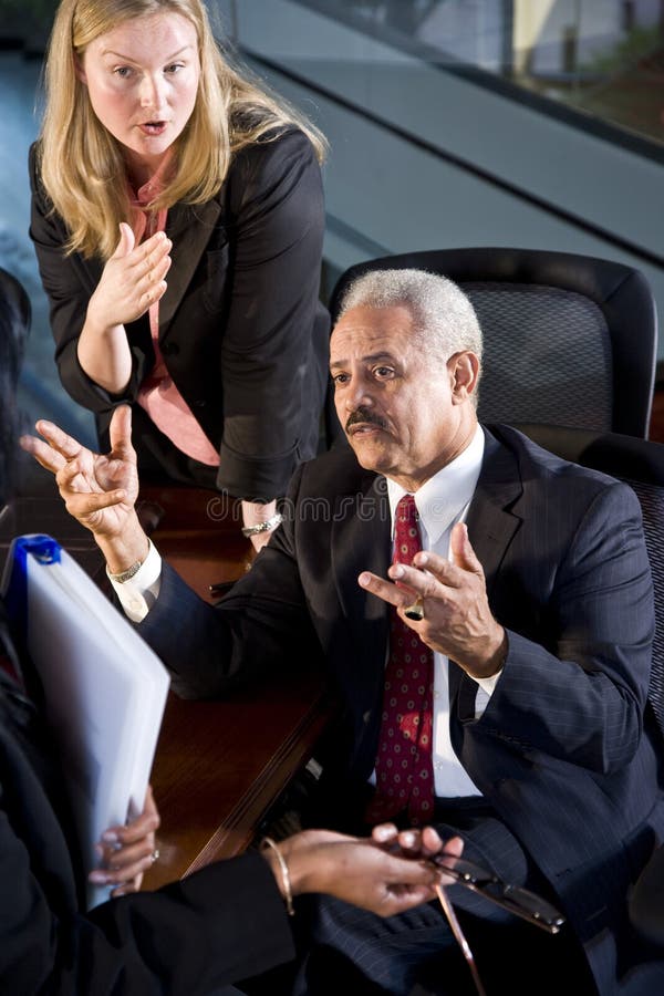 Multi-ethnic businesspeople in boardroom having a serious conversation. Negotiating table stock images, royalty-free photos and pictures