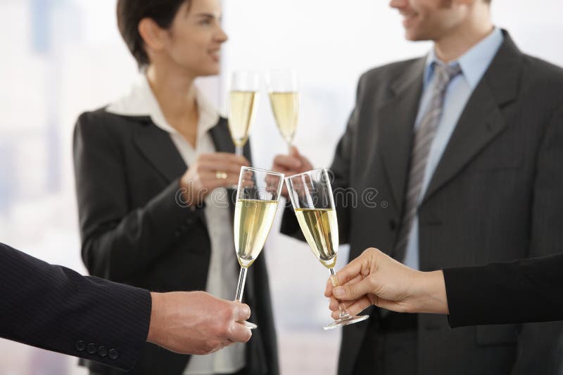 Business people raising toast with champagne