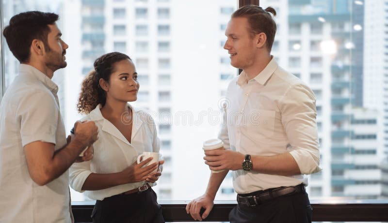 Business people talking and holding cups of coffee with city view .Group of coworkers having a coffee break in office. royalty free stock images Business people talking and holding cups of coffee with city view .Group of coworkers having a coffee break in office. royalty free stock images