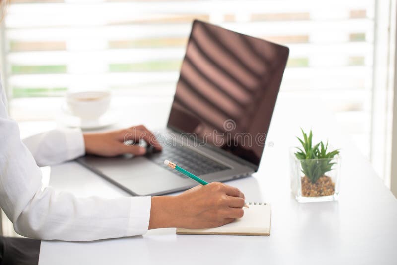 Business people work Laptop screen The hand is taking notes Office room. Online marketing concepts, adult education, e-learning