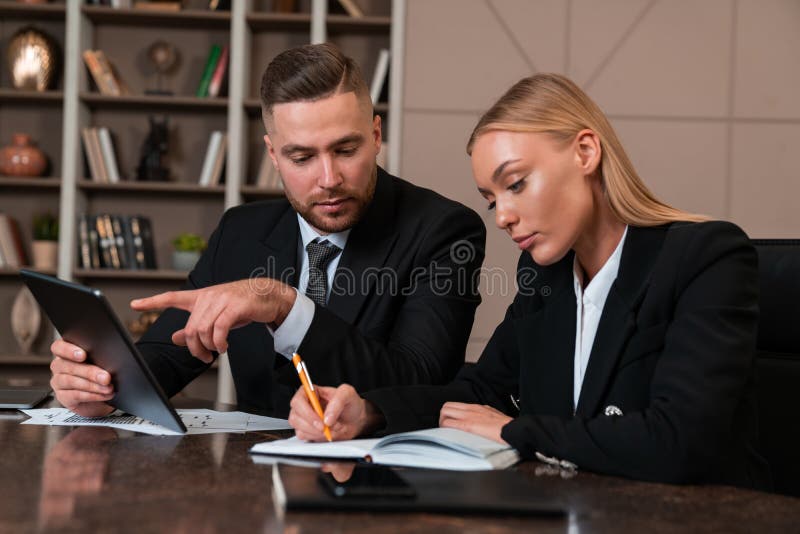 Business people working together with tablet and taking notes stock photography