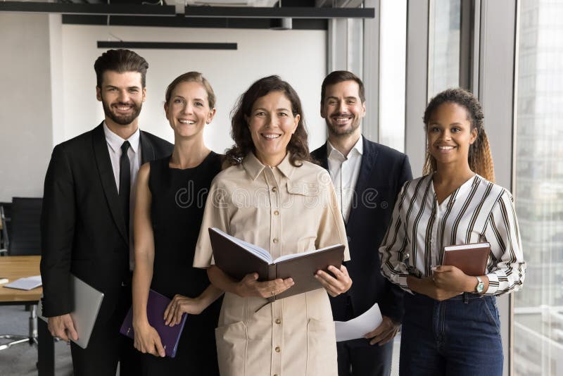 Business professionals posing for camera standing together in office stock photos