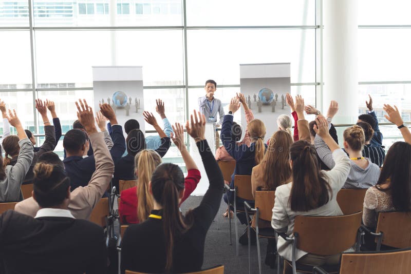 Business professionals raising hands in a business seminar royalty free stock photo Business professionals raising hands in a business seminar royalty free stock photo