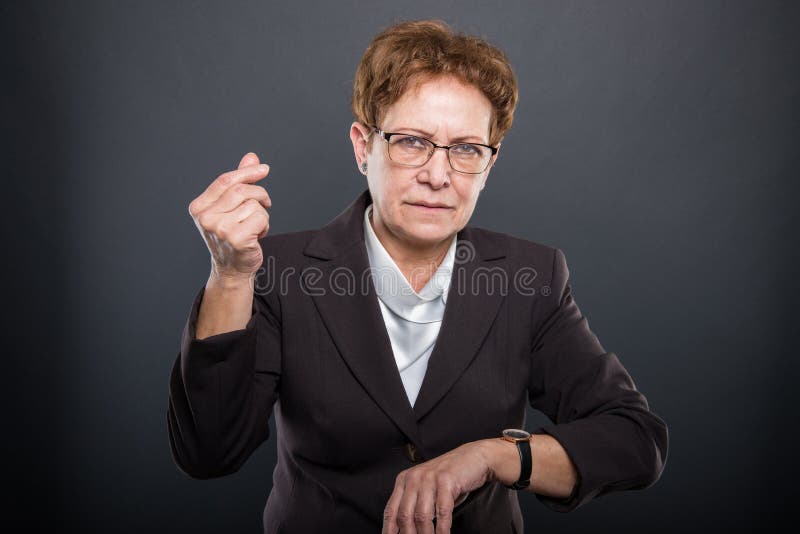 Business senior lady showing time is money gesture stock photography Business senior lady showing time is money gesture stock photography