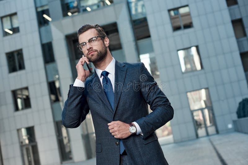 Business talk. Handsome young man in full suit talking on the phone. Cropped view