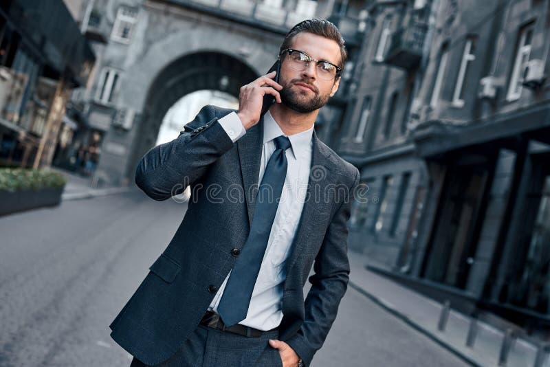 Business talk. Handsome young man in full suit talking on the phone. Cropped view