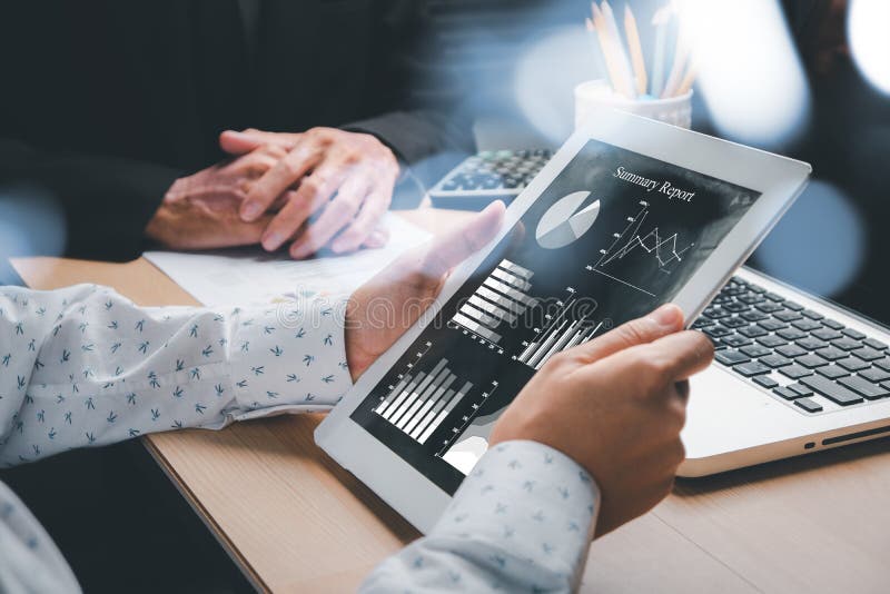 Business-Team analysiert Einkommenskarten und Grafiken mit modernen Laptops und Tablet-Computern stockbilder