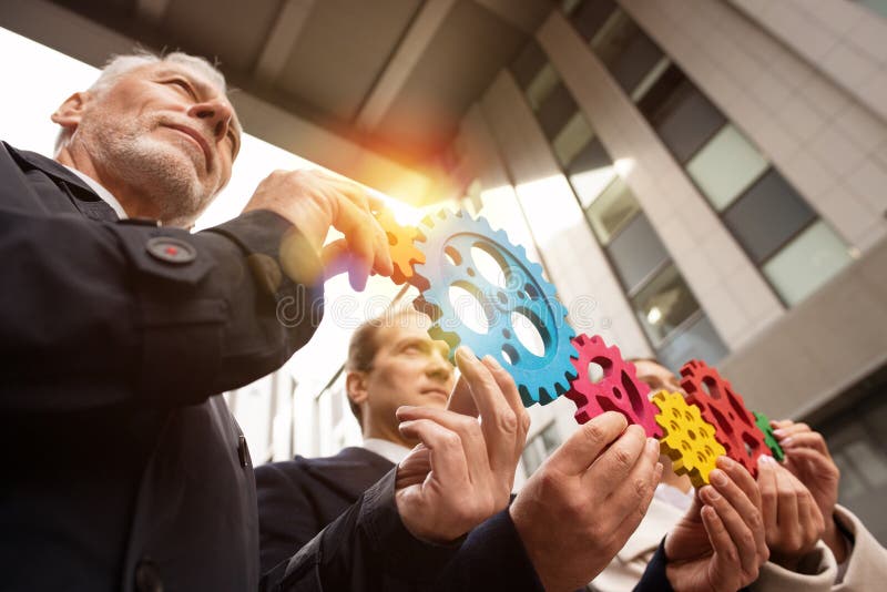 Business team connect pieces of gears. Teamwork, partnership and integration concept stock photo Business team connect pieces of gears. Teamwork, partnership and integration concept stock photo