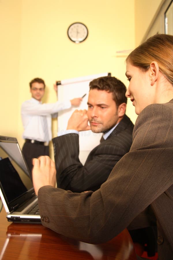 Un team si riunisce in una piccola sala conferenze per studiare e preparare una proposta per un nuovo progetto di business.