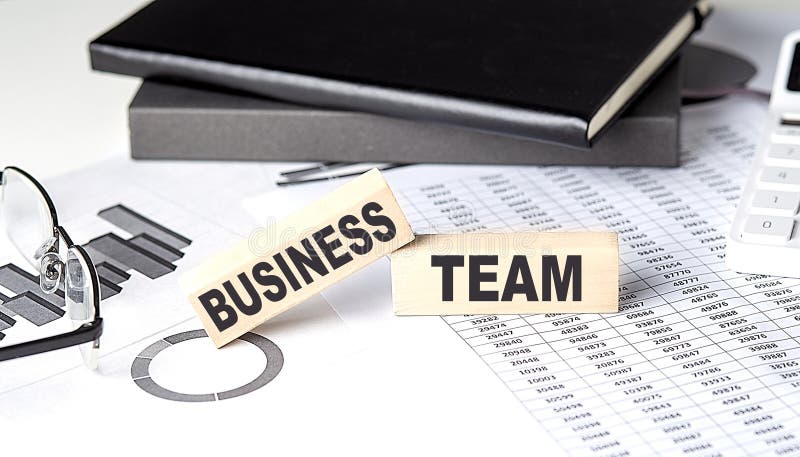 BUSINESS TEAM - text on a wooden block with chart and notebook stock image