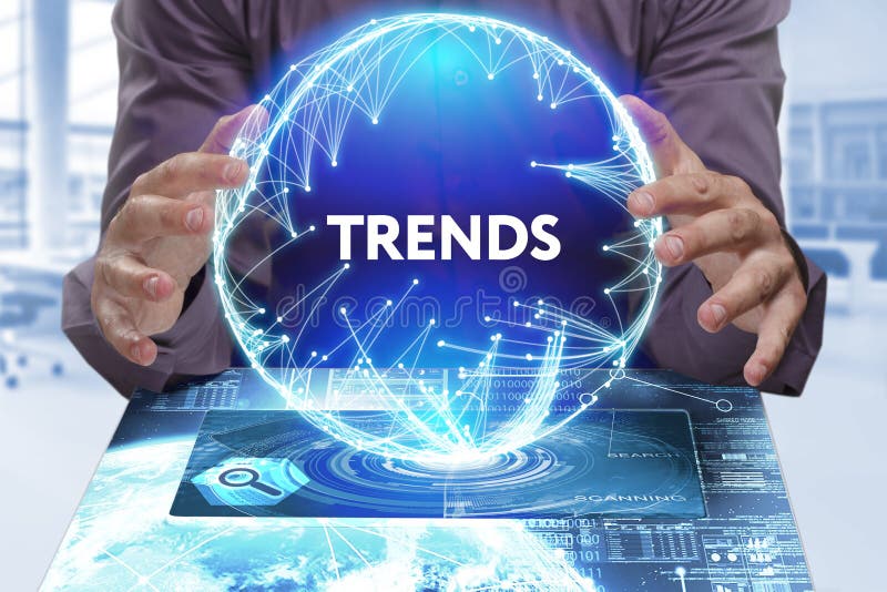 Business, Technology, Internet and network concept. Young businessman shows the word on the virtual display of the future: Trends stock image Business, Technology, Internet and network concept. Young businessman shows the word on the virtual display of the future: Trends stock image