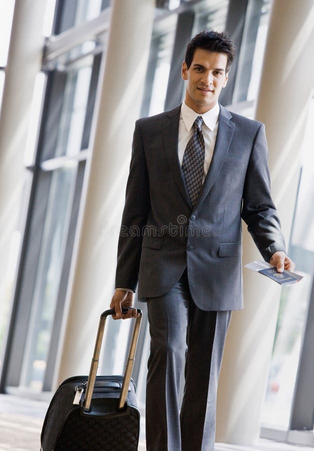 Business traveler pulling suitcase and passport