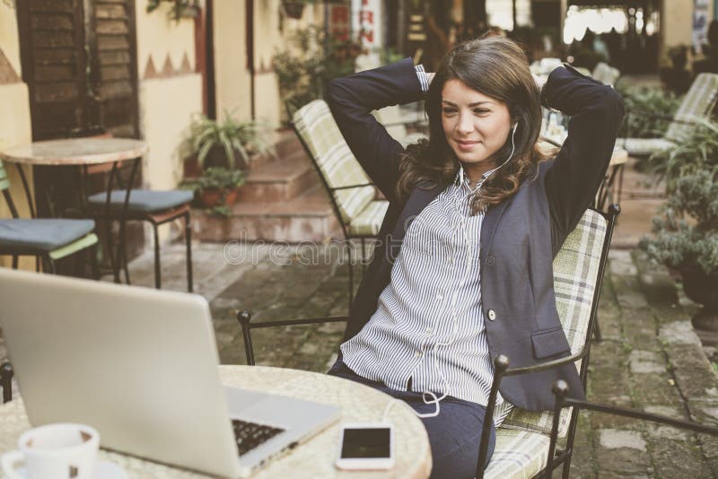 Business woman at cafe take a break from work. Listening music. royalty free stock photography Business woman at cafe take a break from work. Listening music. royalty free stock photography
