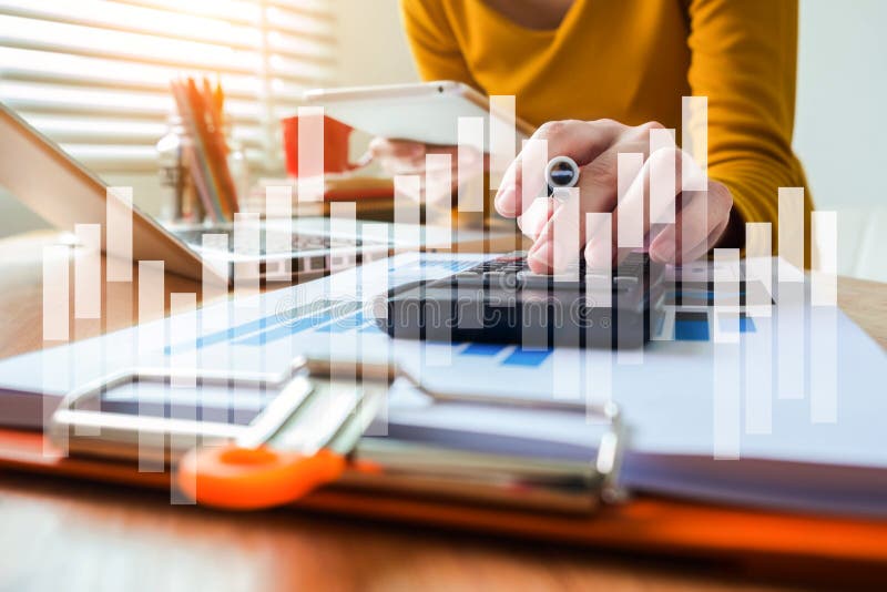 Business woman calculates financials with graph paper on the table on the cost of home office.