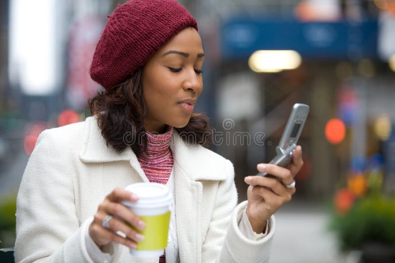 An attractive business woman checking her cell phone in the city. She could be text messaging or even browsing the web via wi-fi or a 3g connection. An attractive business woman checking her cell phone in the city. She could be text messaging or even browsing the web via wi-fi or a 3g connection.