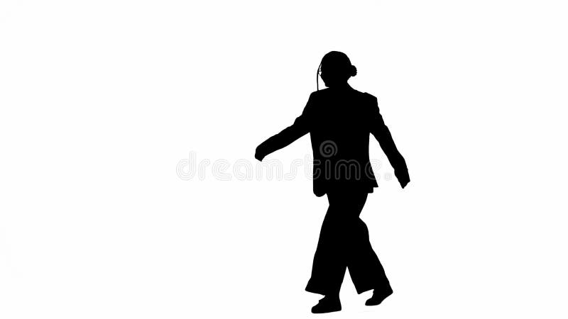 Business woman in formal outfit walking in headphones listening music on smartphone. Half-turn. Black silhouette on a