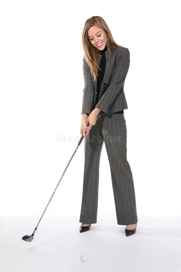 A pretty young business woman getting ready to swing at a golf ball. A pretty young business woman getting ready to swing at a golf ball