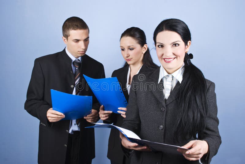 Business woman in front of image holding a folder document and other business people in background with folders reading contracts,check also. Business woman in front of image holding a folder document and other business people in background with folders reading contracts,check also