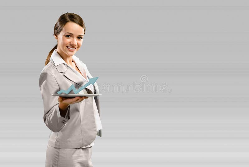 Attractive business woman holding a tablet with a sign of the growing graph, financial concept