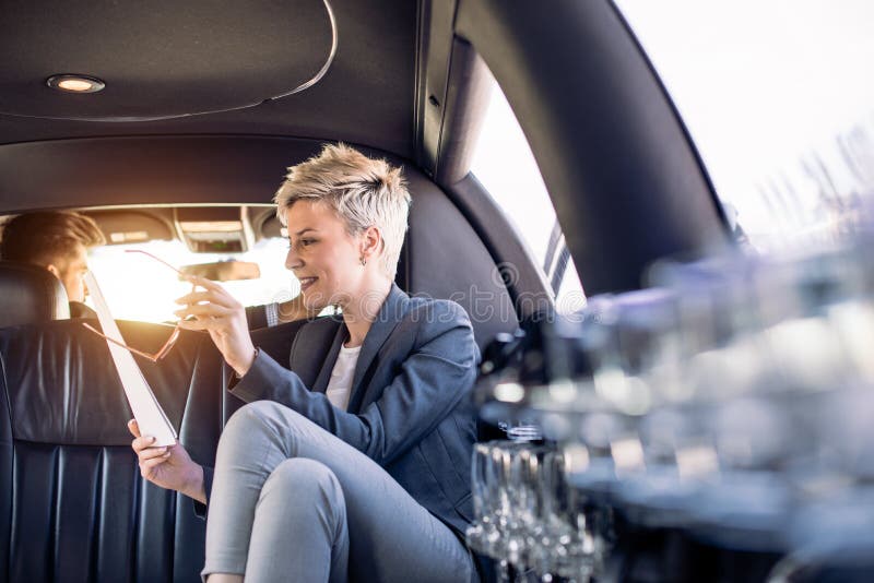 Business woman in limousine looking at documents