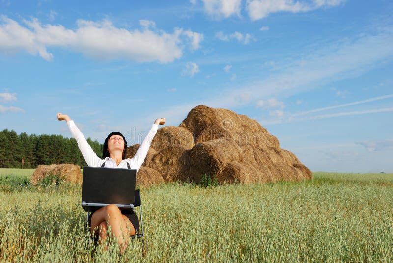 Young attractive girl with laptop on agricultural field. Young attractive girl with laptop on agricultural field