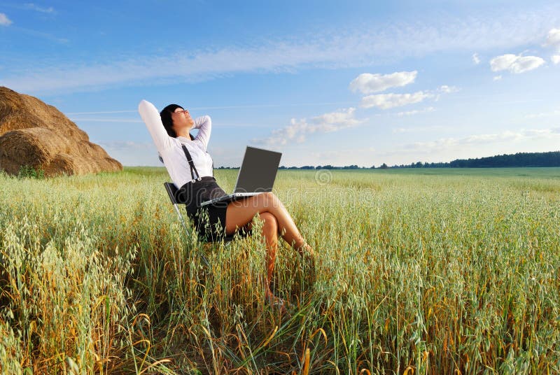 Young attractive girl with laptop on agricultural field. Young attractive girl with laptop on agricultural field