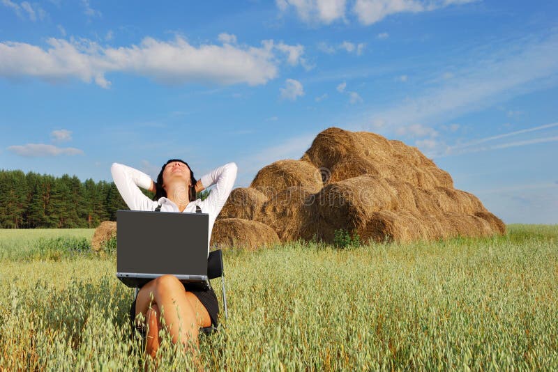 Young attractive girl with laptop on agricultural field. Young attractive girl with laptop on agricultural field