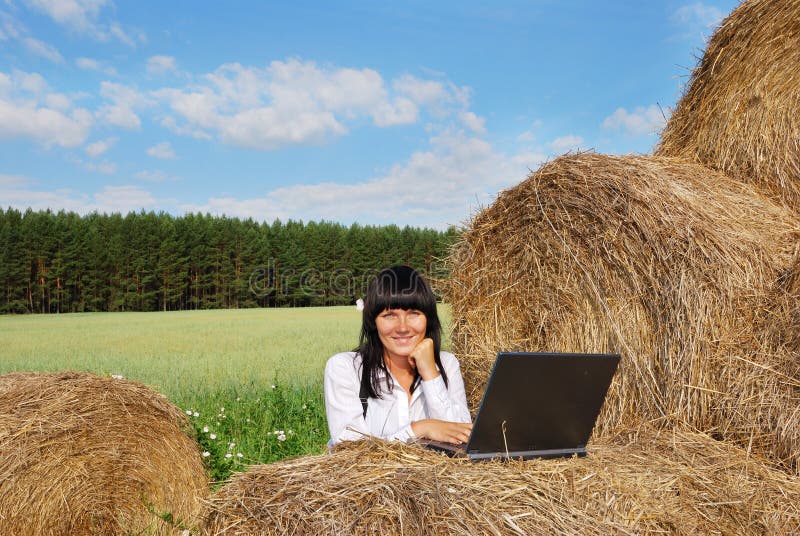 Young attractive girl with laptop on agricultural field. Young attractive girl with laptop on agricultural field