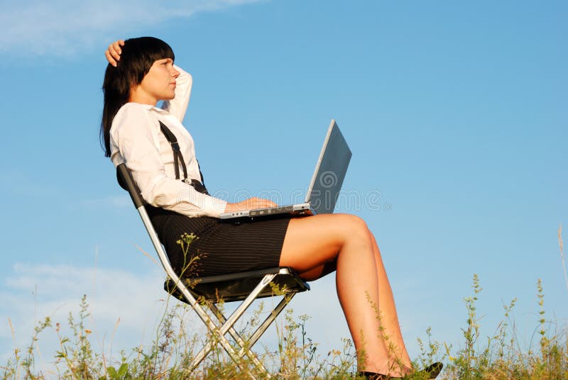 Attractive young girl working on computer in nature. Attractive young girl working on computer in nature