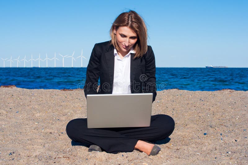 Business woman on the sand with laptop