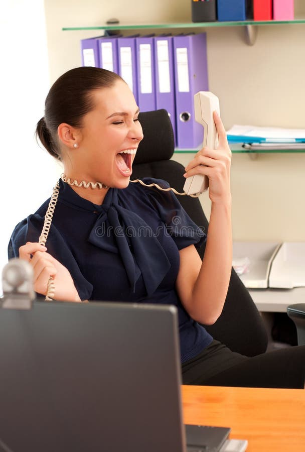 Business woman screaming in telephone receiver