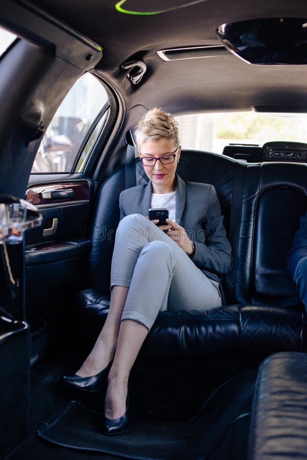 Business woman texting in limo