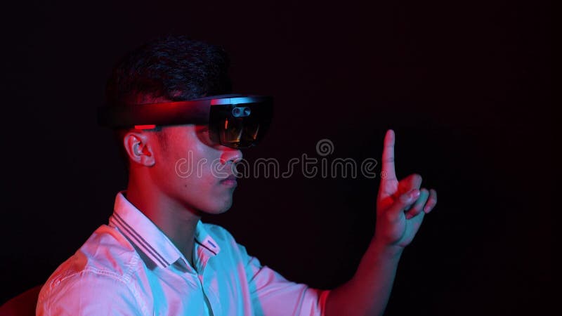 Business man try vr glasses hololens in the dark room. Portrait of young asian boy experience ar communication. Future