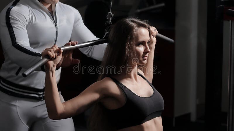 Business woman with a personal trainer engaged in the gym.