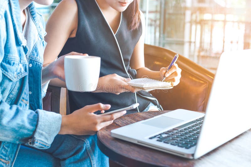 Business women work on a computer and take notes in a notebook stock images Business women work on a computer and take notes in a notebook stock images