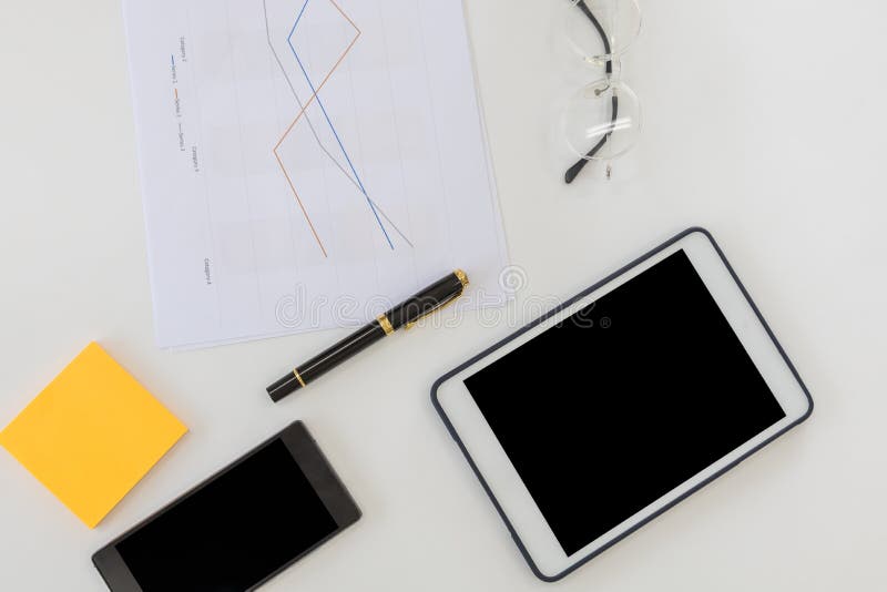 Business and Workplace concpet. Top view of work desk with blank screen tablet, smart mobile phone document paper line chart, pen royalty free stock image Business and Workplace concpet. Top view of work desk with blank screen tablet, smart mobile phone document paper line chart, pen royalty free stock image