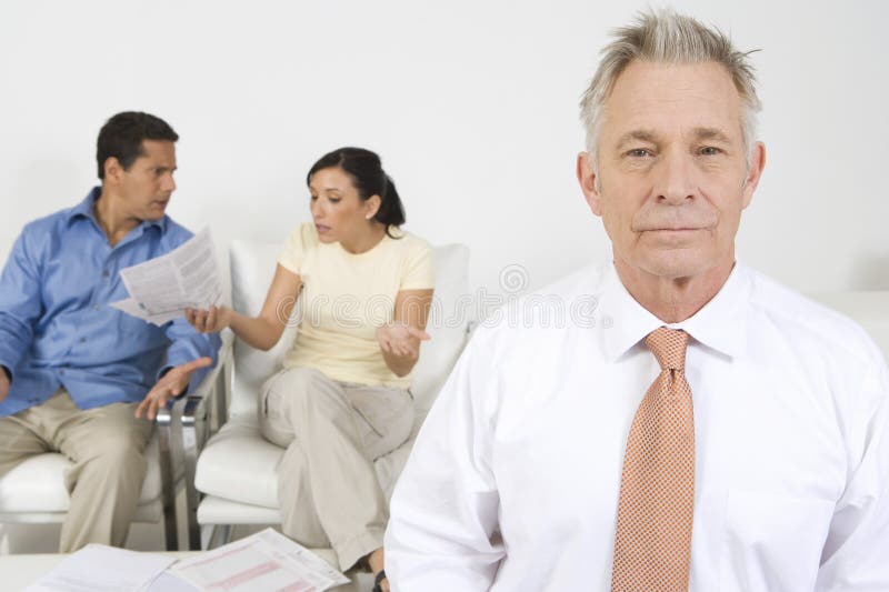 Senior financial advisor with couple arguing in background. Senior financial advisor with couple arguing in background