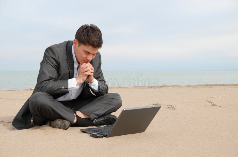 Businessman on beach with laptop