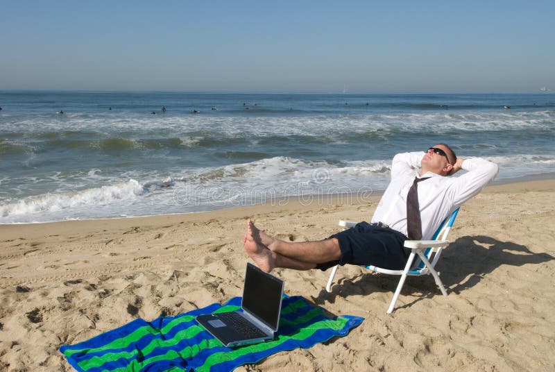 Businessman on beach with laptop