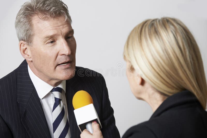 Businessman Being Interviewed By Female Journalist With Microphone
