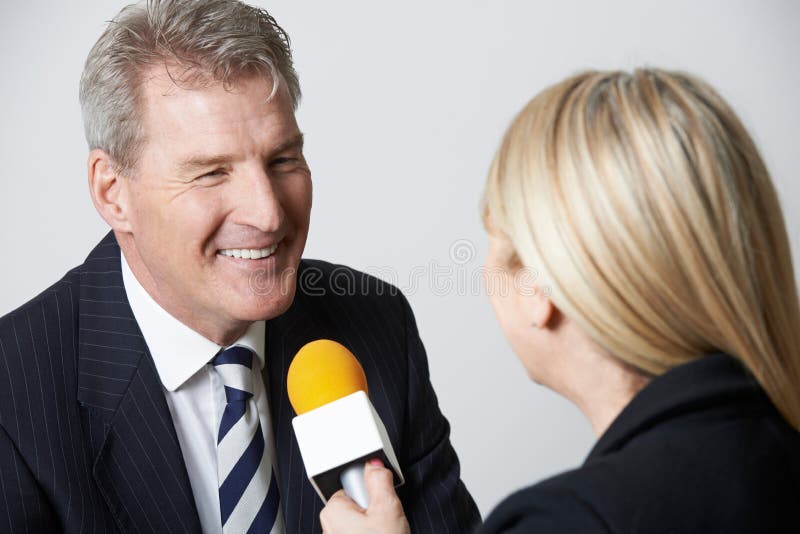 Businessman Being Interviewed By Female Journalist With Microphone stock image