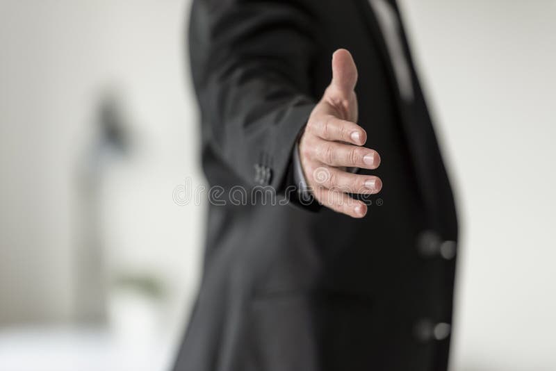 Businessman in black business suit offering you a handshake stock images Businessman in black business suit offering you a handshake stock images