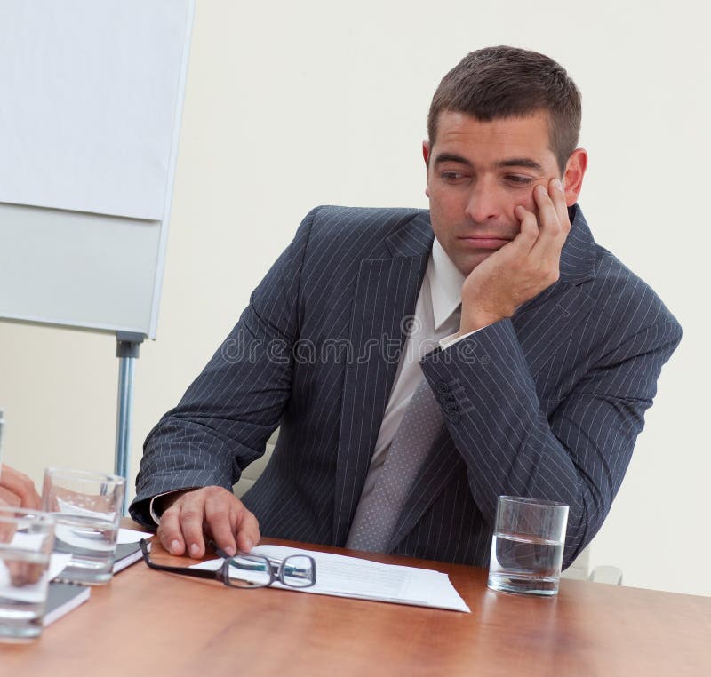 Attractive young businessman bored in a meeting