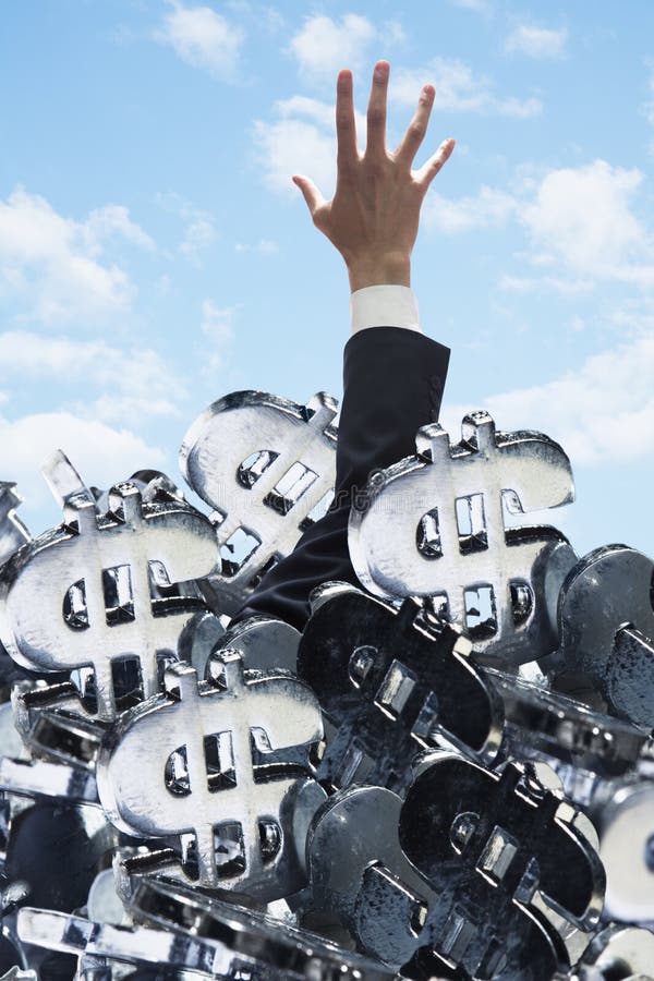Businessman buried under a large group of dollar signs, trying to get out stock photography Businessman buried under a large group of dollar signs, trying to get out stock photography