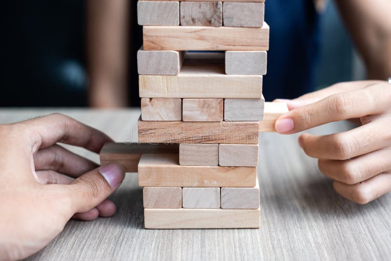 Businessman and Businesswoman hand placing or pulling wooden block stock images Businessman and Businesswoman hand placing or pulling wooden block stock images