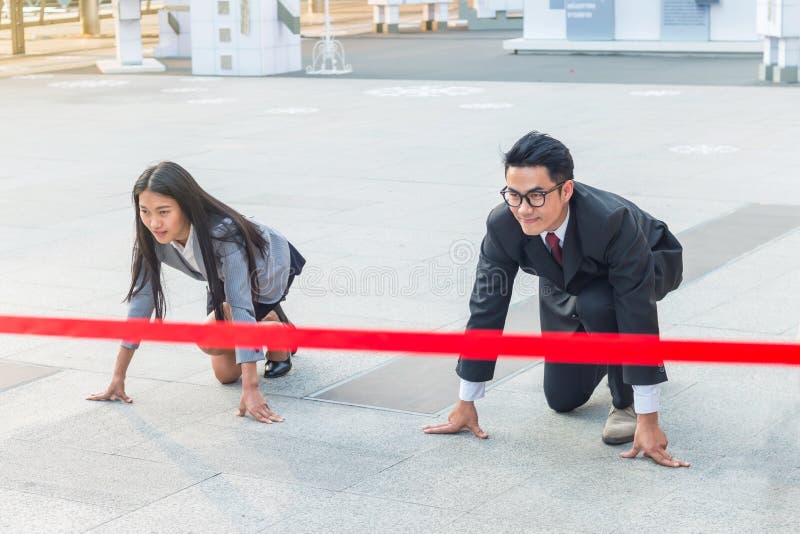 The businessman and businesswoman ready to run on start position with commitment to success stock image The businessman and businesswoman ready to run on start position with commitment to success stock image