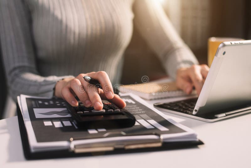 Businessman calculates financials with graph paper on the table on the cost of home office.