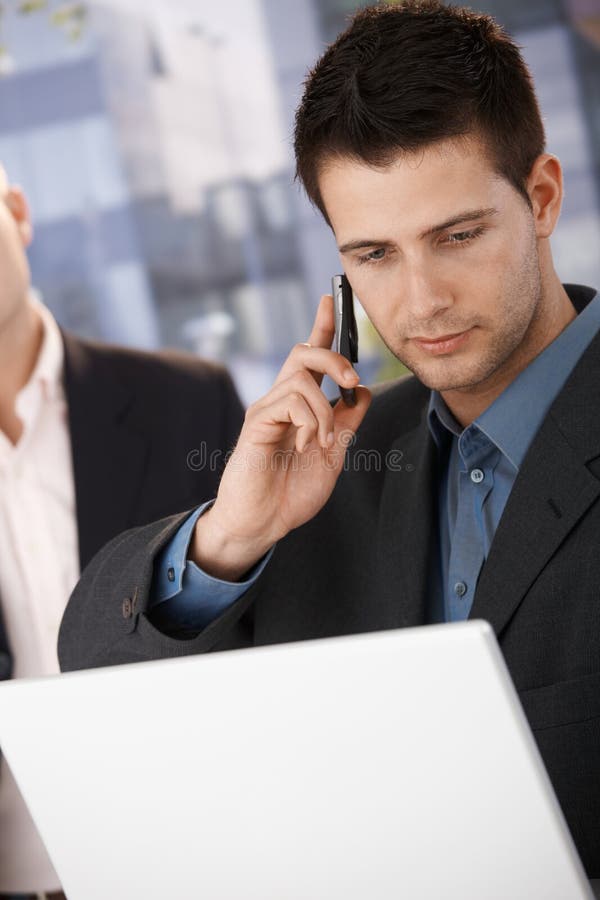 Businessman on call holding laptop