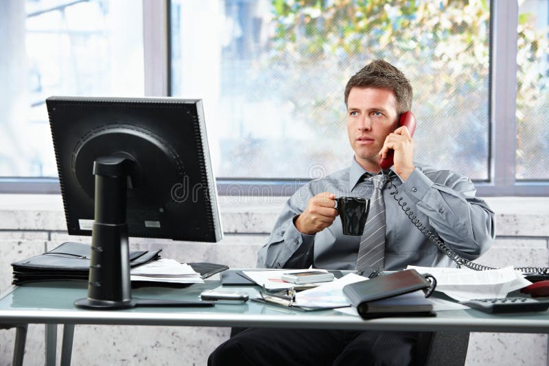 Businessman calling at office with mug royalty free stock images Businessman calling at office with mug royalty free stock images
